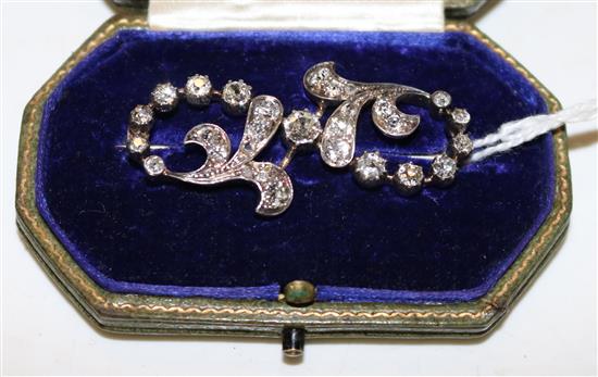 An Edwardian gold, silver and diamond openwork scroll brooch, in Shapland, London box.